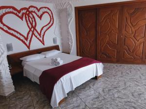 Un dormitorio con una cama con corazones pintados en la pared en Suítes Bela Vista en Japaratinga