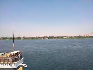 a boat in the water on a river at Nile queen Apartments for Rent in Luxor