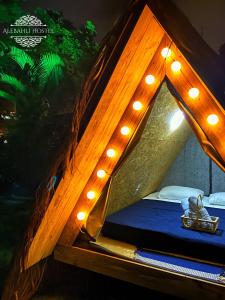 a bedroom with a tent with lights on it at Smartcamp Ilhabela ᵇʸ ᴬᴸᴱᴮᴬᴴᴸᴵ in Ilhabela