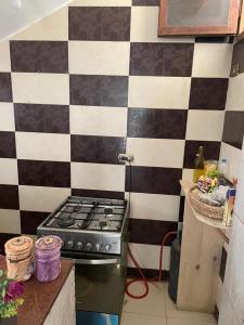 a kitchen with a black and white checkered wall at Seif's house in Dahab