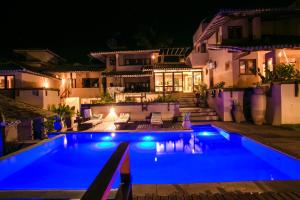 une villa avec une piscine la nuit dans l'établissement Baixu Village, à Arraial d'Ajuda