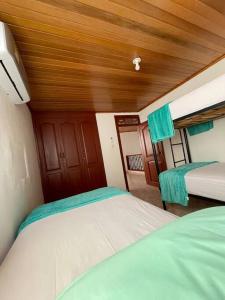 a bedroom with two beds and a wooden ceiling at Casa Marina Espectacular Casa Completa in Valledupar