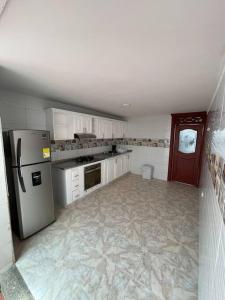 una cocina con nevera de acero inoxidable y armarios blancos en Casa Marina Espectacular Casa Completa en Valledupar