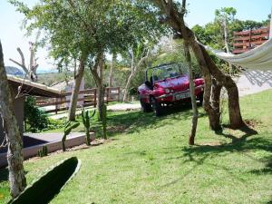 un camión rojo estacionado en un patio con una hamaca en Chez monsieur, en Búzios