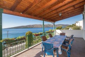 a deck with a table and chairs and a view of the water at Apartment Marijana in Seget Vranjica