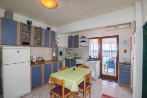a kitchen with blue cabinets and a table and a table and chairs at Apartment Marijana in Seget Vranjica