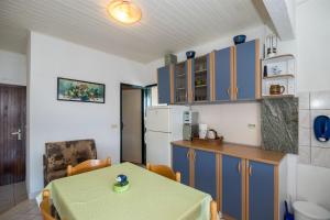 a room with a table and a kitchen with blue cabinets at Apartment Marijana in Seget Vranjica