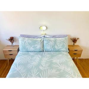 ein Bett mit blauer und weißer Bettwäsche und zwei Nachttischen in der Unterkunft Coolangatta YHA Backpackers in Gold Coast