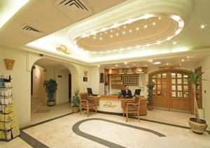 a man sitting at a desk in a lobby at Delmon Suites in Amman