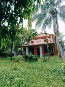a house with a palm tree in front of it at Weekend Villa at Nature's Lap (Malshej Ghat) in Ghātghar
