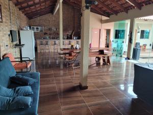 特林达迪SONHO DE CHACARA PIQUIA II的客厅铺有木地板,配有桌椅。