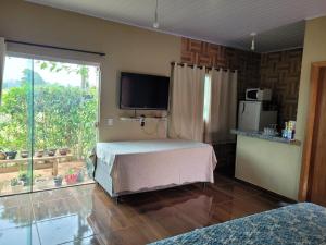 特林达迪SONHO DE CHACARA PIQUIA II的房间里有一张床和一台电视的卧室 更多16张照片