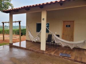 特林达迪SONHO DE CHACARA PIQUIA II的房屋内带吊床的门廊