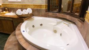 a large white tub in a bathroom with a sink at Castillo San Carlos Lomas de Cocoyoc con Cancha de Padel 16Huespedes in Cocoyoc +16 photos