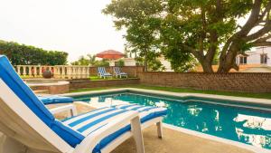 a swimming pool with two lounge chairs next to it at Castillo San Carlos Lomas de Cocoyoc con Cancha de Padel 16Huespedes in Cocoyoc