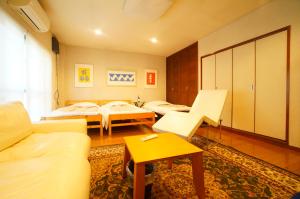 salon z 2 łóżkami i kanapą w obiekcie Tomato Villa Takayama Station w mieście Takayama