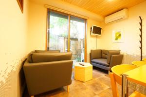 sala de estar con 2 sillas y ventana en Momiji Takayama en Takayama