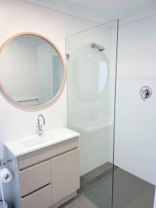 a white bathroom with a sink and a mirror at Abbey House - 3BR/sleeps 8 - South Leura in Leura