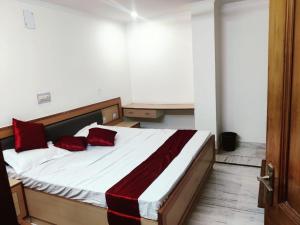 HisārにあるHotel veersarthak residencyのベッドルーム1室(大型ベッド1台、赤い枕付)