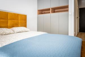ein Schlafzimmer mit einem großen Bett mit einer blauen Decke in der Unterkunft Apartamenty Przy IV Śluzie - Gold in Bydgoszcz