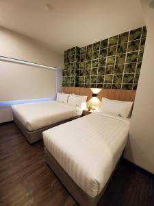 a hotel room with two beds and a wall at Apex Boutique Hotel @ Bandar Sunway in Petaling Jaya