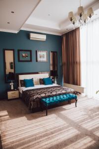 um quarto com uma cama grande e paredes azuis em Chernivtsi Arbat em Chernivtsi