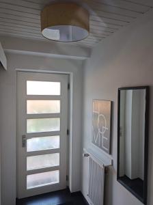 a hallway with a door and a mirror and a window at Relaxen vor den Toren Bambergs in Bischberg