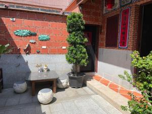 einen Tisch und einen Baum vor einem Gebäude in der Unterkunft Xinqin B&B - City Area in Jincheng