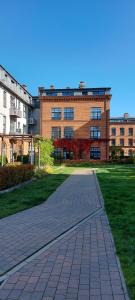 a brick building with a brick walkway in front of it at Loft Niezapominajka w Tobaco Park in Łódź