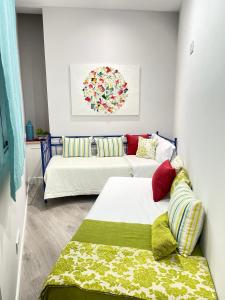 a living room with two beds and a couch at Alojamiento Hermanos Garnelo in Montilla