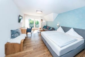 a bedroom with a bed and a living room at Ferienhotel Haus Becker in Bad Laer