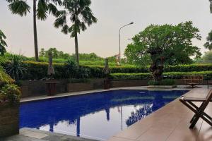 a swimming pool in a resort with trees and bushes at Apt 2 BR Sunter Park View With Pool and Netflix in Jakarta