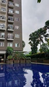 a building and a swimming pool in front of a building at Apt 2 BR Sunter Park View With Pool and Netflix in Jakarta