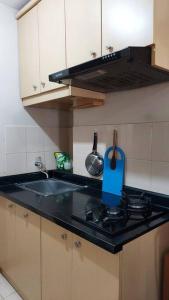 a kitchen with a sink and a stove top oven at Apt 2 BR Sunter Park View With Pool and Netflix in Jakarta