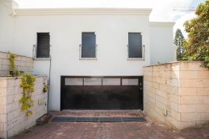 una puerta de garaje frente a una casa blanca en Sheba-Shik apartment, Tel hashomer שיבא-שיק, תל השומר,דירת סטודיו מקסימה! en Ramat Gan