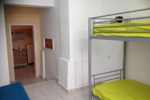 Habitación con litera y sábanas amarillas. en Apartment 10 min from the center of Heraklion, en Heraclión