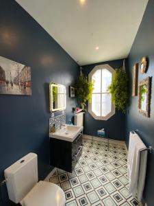 Maison Belmont Eymet في إيميت: حمام ازرق مع مرحاض ومغسلة