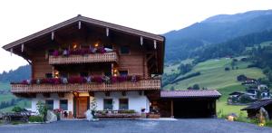 a building with a balcony with flowers on it at Ferienwohnung Lerchenhof in Wald im Pinzgau