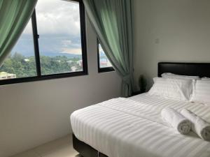 - une chambre avec un lit blanc et 2 fenêtres dans l'établissement ASR HOMES, iCON RESIDENCE, à Kuala Terengganu