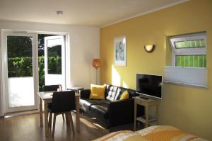 uma sala de estar com um sofá e uma mesa em Duinen Paradijs Zandvoort em Zandvoort