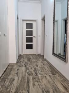 un pasillo vacío con un espejo y una puerta en City Inn Premium Apartment 2, en Timisoara