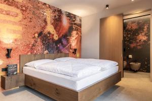 un letto in una stanza con un quadro sulla parete di Stadele a Lana