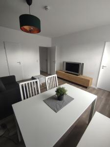 a living room with a white table and a television at Cityapartment in Stadtlohn