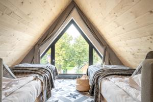 dwa łóżka w pokoju z dużym oknem w obiekcie Apartamenty Pod Stokiem Nosal Zakopane w Zakopanem