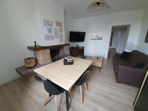 uma sala de estar com uma mesa de madeira e um sofá em "Le Petit Paradis" au Centre Ville d'Oyonnax em Oyonnax