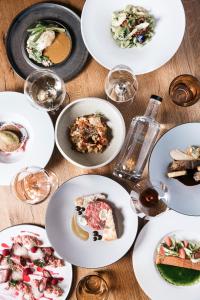 Stadele في لانا: طاولة مع أطباق من الطعام وكؤوس من النبيذ