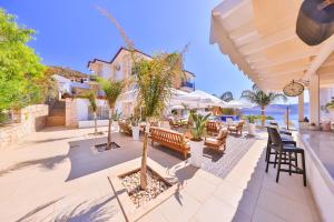 a patio with chairs and tables and a tree at La Kumsal Hotel in Kaş