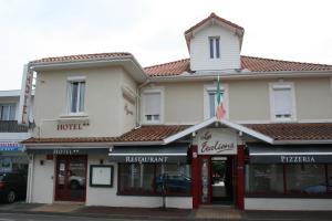 a hotel on the corner of a street at Hôtel Les Italiens in Biscarrosse
