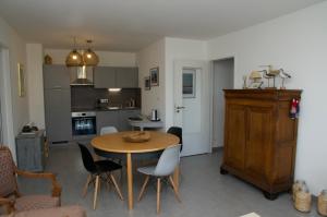 - une cuisine et une salle à manger avec une table et des chaises dans l'établissement Sur le chemin des phoques, à Saint-Valery-sur-Somme