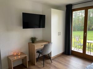 a room with a desk and a television on the wall at Seaways Apartments in Schiefling am See